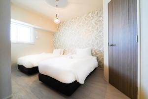 那覇市にあるBranchera Naha 1402の白いシーツが敷かれたホテルの部屋にベッドが2つある +64枚の写真