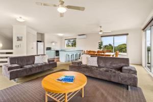 a living room with two couches and a table at Views on Bayview in Cowes