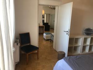 a room with a bedroom with a bed and a chair at studio e - Quiet central business one bedroom apartment for 3 guests in Düsseldorf