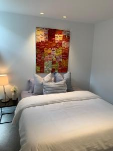 a bedroom with a bed with a painting on the wall at Designer Luxury for 2 in Mornington