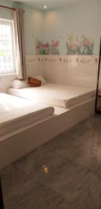 2 camas individuais num quarto com uma janela em Ngan Giang Guesthouse em Phu Quoc