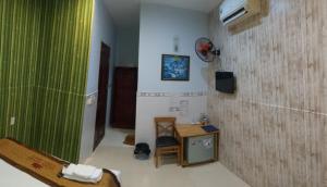 a room with a table and a green wall at Ngan Giang Guesthouse in Phú Quốc