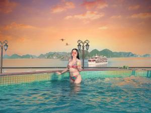 a woman standing in the water in a swimming pool at Aspira Cruise in Ha Long