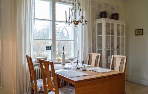 a dining room table with chairs and a large window at Awesome Home In Hallstavik With Wifi in Hallstavik