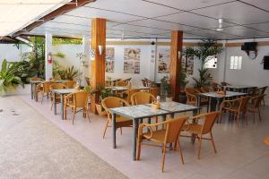 a restaurant with tables and chairs and plants at Marcosas Cottages Resort in Moalboal