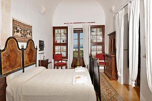 ein Schlafzimmer mit einem großen Bett und ein Zimmer mit Fenstern in der Unterkunft Masseria Spina Resort in Monopoli