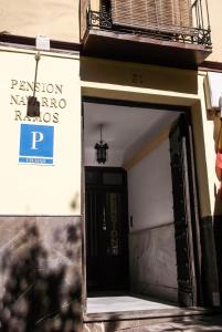una puerta abierta de un edificio con un cartel. en Pensión Ciudad Navarro Ramos en Granada