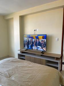 a bedroom with a flat screen tv on a wall at Casa Galarza in Huancayo