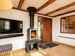 a wood stove in a living room with a door at 6 person holiday home in Sp ttrup in Lihme