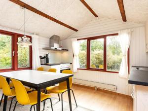 a kitchen and dining room with a table and yellow chairs at 6 person holiday home in Sp ttrup in Lihme