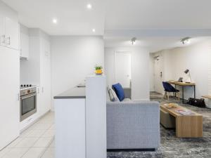 a kitchen and living room with a couch and a table at Brady Apartment Hotel Flinders Street in Melbourne