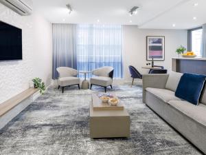 a living room with a couch and a table at Brady Apartment Hotel Flinders Street in Melbourne