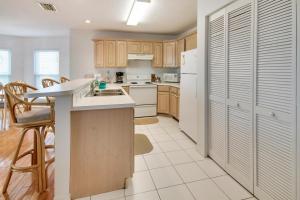 a kitchen with wooden cabinets and a white refrigerator at Amadeus 6 in St. Pete Beach