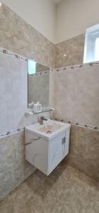 uma casa de banho com um lavatório branco e um espelho. em Châu Gia Villa Vũng Tàu - Có chỗ đậu xe hơi em Vung Tau