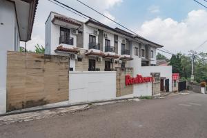 a white building with a red sign on it at RedDoorz at Dago Asri 3 in Bandung