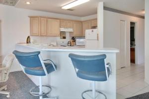 a kitchen with two blue chairs at a counter at Amadeus 3 in St. Pete Beach