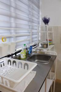 um balcão de cozinha com um lavatório e uma janela em The_Mozy Homestay em Tanjong Sepat