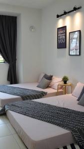 um quarto com duas camas num quarto em The_Mozy Homestay em Tanjong Sepat