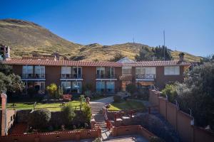 ein großes Haus mit einem Berg im Hintergrund in der Unterkunft Casa Andina Premium Puno in Puno