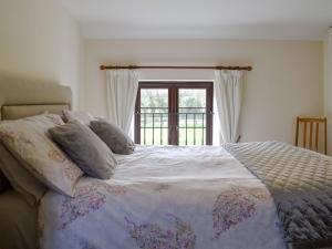 a bedroom with a large bed with a window at The Stables in Alton Pancras