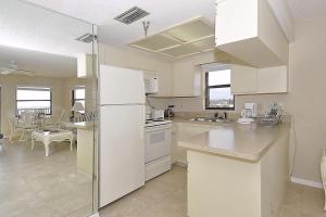 uma cozinha com electrodomésticos brancos e uma sala de jantar em Emerald Isle 601 em St. Pete Beach