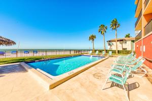a swimming pool with chairs and the beach at Emerald Isle 204 in St. Pete Beach