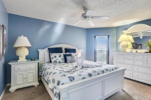 a bedroom with a white bed and blue walls at Emerald Isle 602 in St. Pete Beach