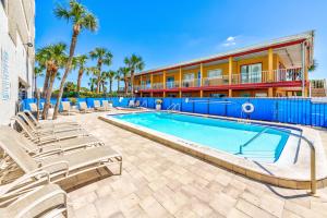 a swimming pool with lounge chairs and a building at Arie Dam 304 in St. Pete Beach