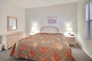 a bedroom with a bed and two night stands and two lamps at Amadeus 2 in St. Pete Beach