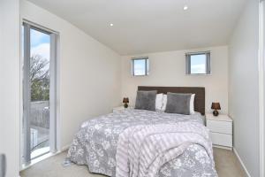 Tempat tidur dalam kamar di Regents 94 - Christchurch Holiday Homes