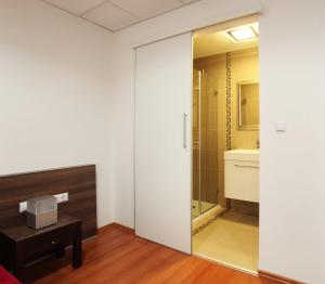 baño con una puerta de cristal que conduce a una ducha en Sós Motel, en Hatvan