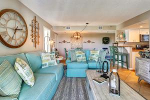 a living room with a blue couch and a clock at Caprice 401 in St. Pete Beach