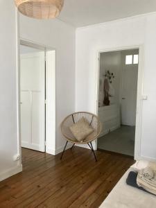 a white room with a chair and a mirror at Esprit Cosy in Alençon