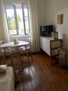 a small living room with a table and a television at Esprit Cosy in Alençon