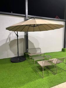 a group of chairs and an umbrella on the grass at Mahayahay Lodge and Restaurant in Mactan