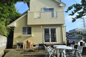 a house with a table and chairs in front of it at ritomaru house iki ashibe in Iki