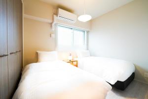 a bedroom with two beds and a window at Branchera Naha 1405 in Naha +72 photos