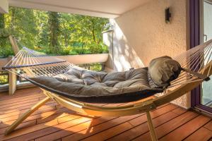 a hammock on a porch with a large window at SweetHome - Luxus pur - große Küche, 2 Bäder, 2 Terrassen in Ottobrunn