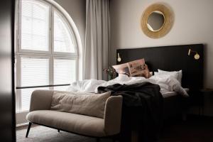 a bedroom with a bed and a chair and a mirror at Bob W Helsinki Katajanokka in Helsinki