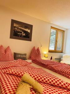 two beds in a room with red pillows at Chalet Sepp in Belalp