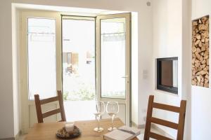 Un comedor con mesa y sillas y ventanas. en Villa Demarino, en Castellana Grotte