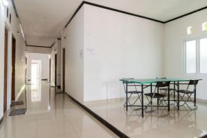 a table and chairs in a room with a wall at RedDoorz near Terminal Bubulak Bogor in Bogor
