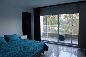 a bedroom with a bed and a large window at Nueva, Moderna casa en Silvania con Jacuzzi in Silvania