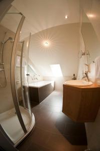 a bathroom with a shower and a sink and a tub at Berghotel Hohe Mark in Reken