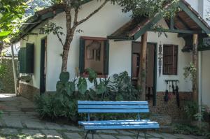 a blue bench in front of a house at Pousada Flor do Mato in Lumiar