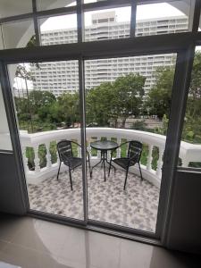 uma varanda com uma mesa e cadeiras num edifício em Dorothys em Pattaya Sul
