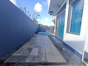 a walkway outside of a building with a swimming pool at R-Villa in Grand Baie