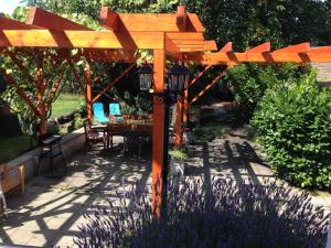 a wooden pergola with a lamp in a garden at Gästehaus Peterhoff in Düren - Eifel