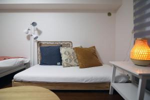 a small room with a bed with pillows on it at GM Shinjuku in Tokyo