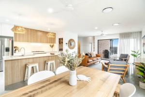 a kitchen and living room with a wooden table at Coast in Lennox Head